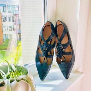 Black flats with strapped cross detailing and tie